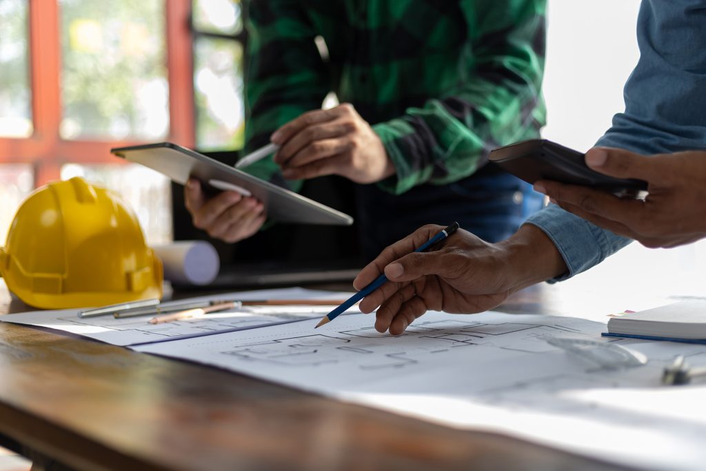 Construction and structure concept planning of Engineer or architect meeting for project working with partner and engineering on model building and blueprint in working site.